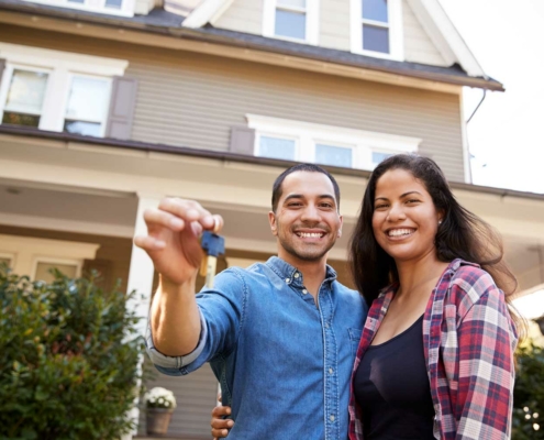 Latino couple with keys to their home